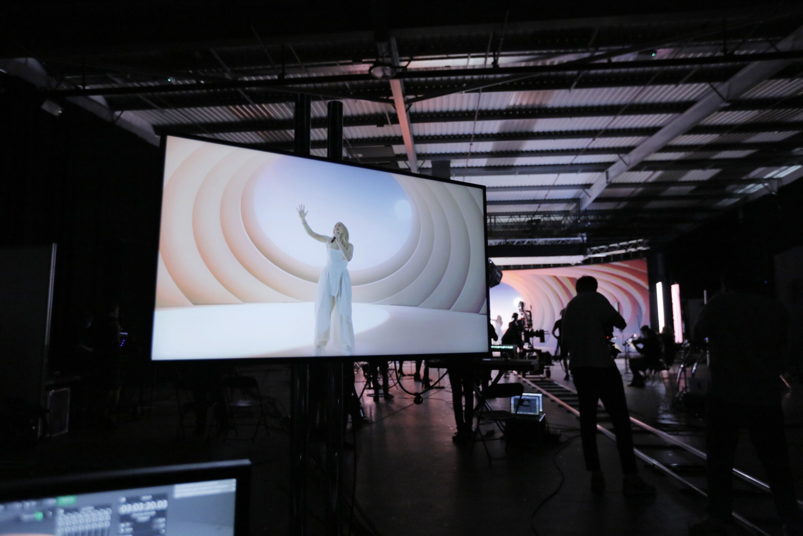 a group of people standing in front of a large screen. Virtual production workflow