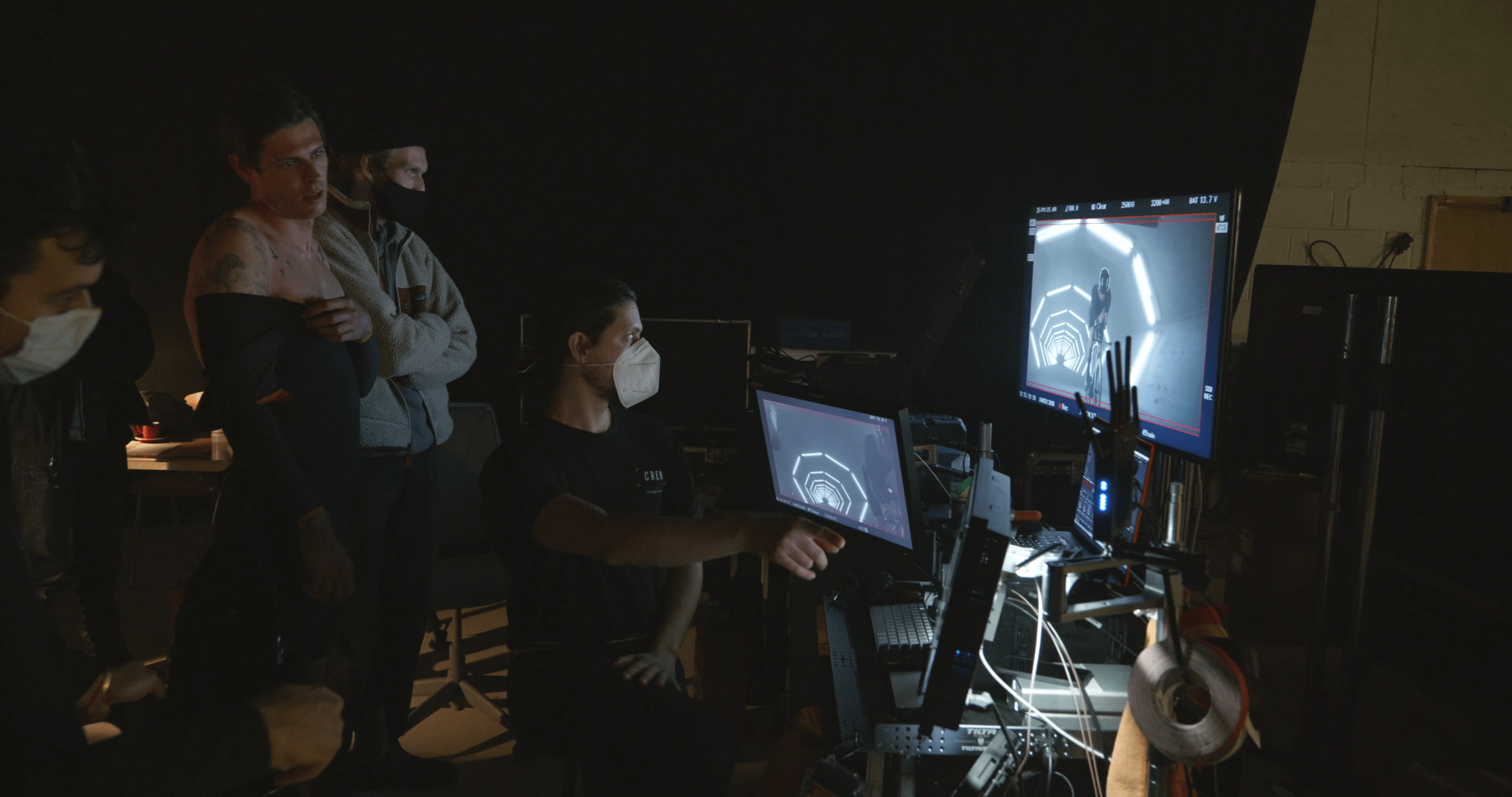 A group of people at LeCol x McLaren in a dark room looking at a computer screen.